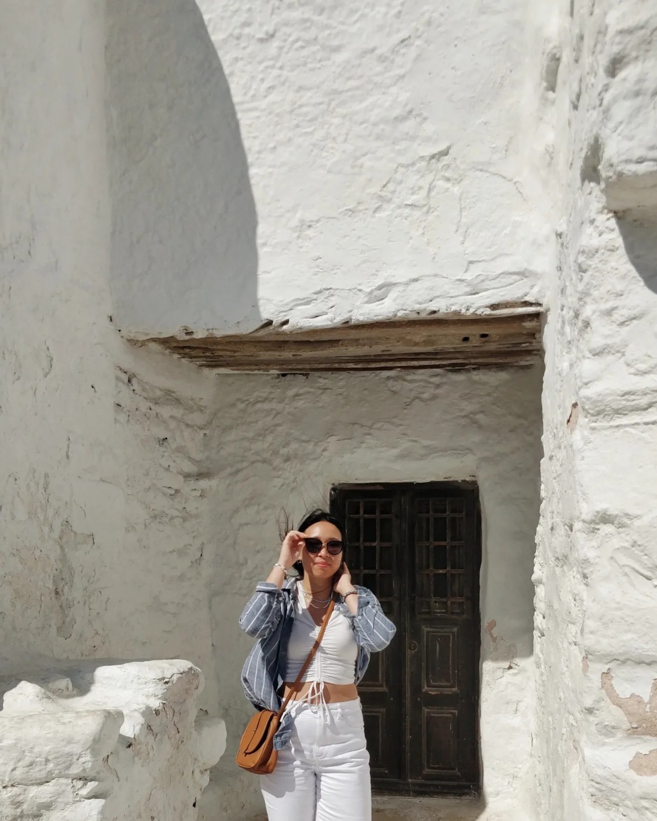 Melissa with sunglasses in front of a door